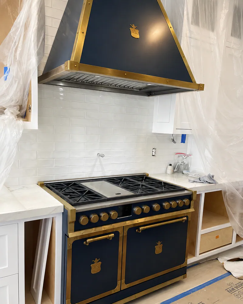 Custom navy range and brass-trimmed hood in Laguna Beach