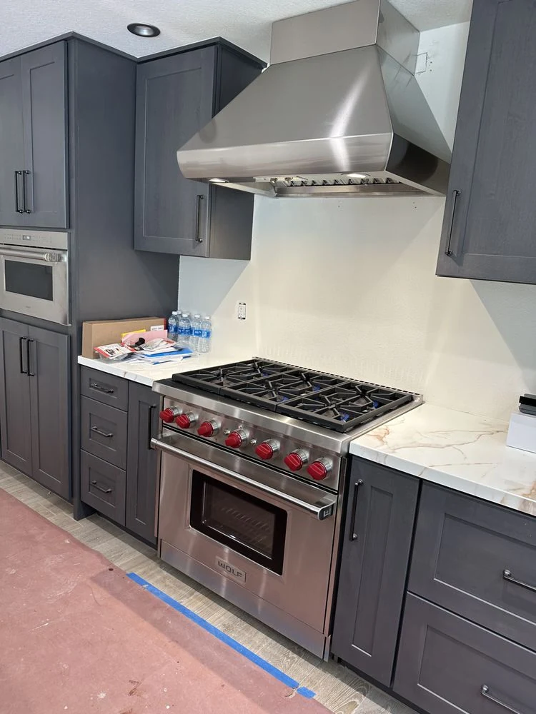 Wolf range with red knobs and custom hood installation in Orange County